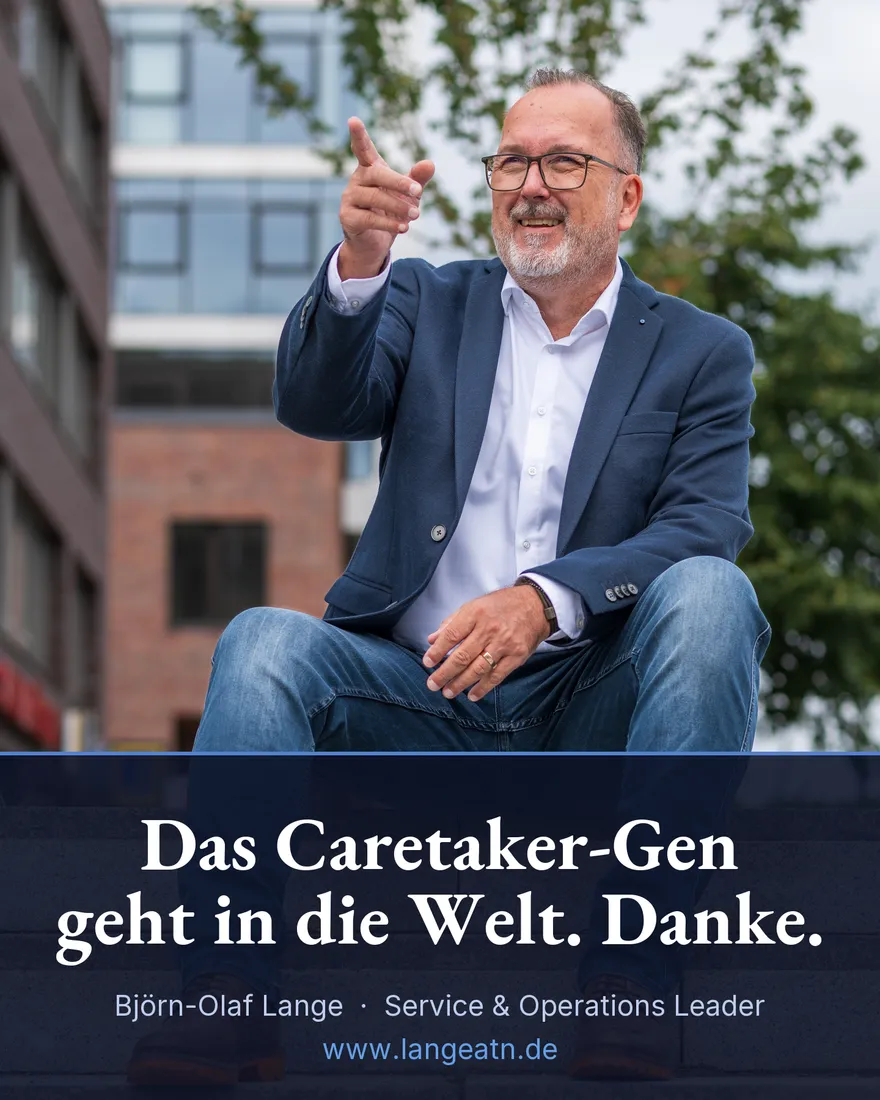Björn-Olaf Lange sitzt lachend auf einer Treppe und zeigt nach vorne, Banderole: Das Caretaker-Gen geht in die Welt. Danke.